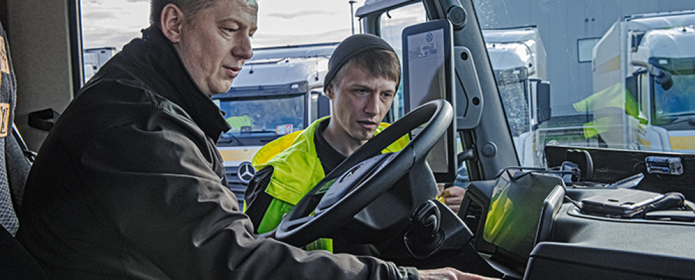 Zwei Männer schauen auf das Amaturenbrett vom LKW
