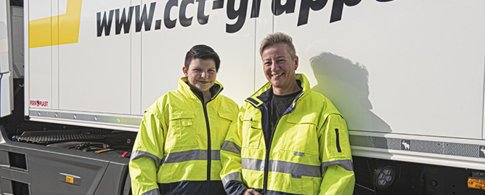 Zwei Personen stehen lächelnd vor einem LKW mit CCT-Aufdruck